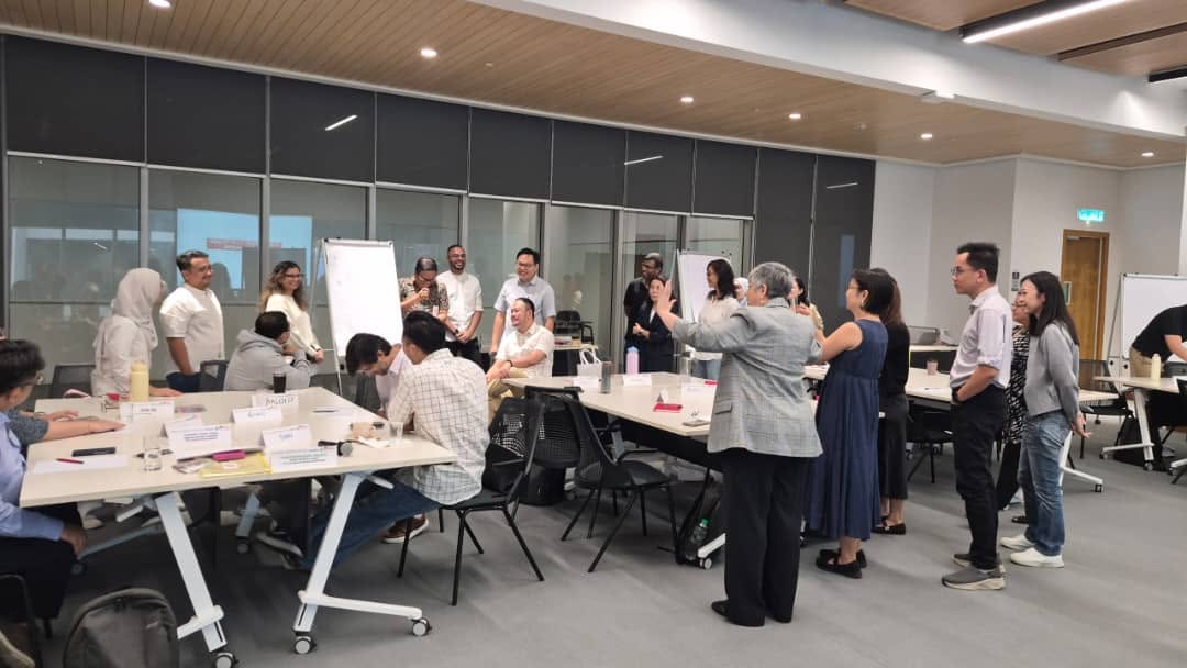 Human Equation's Sheila Singam facilitating a change communication and leadership storytelling workshop for senior staff from Maxis and Asia School of Business in a conference room setting.